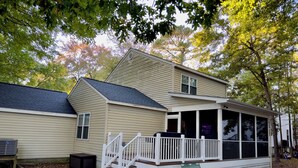 A two-story house with a covered porch and a small front yard.