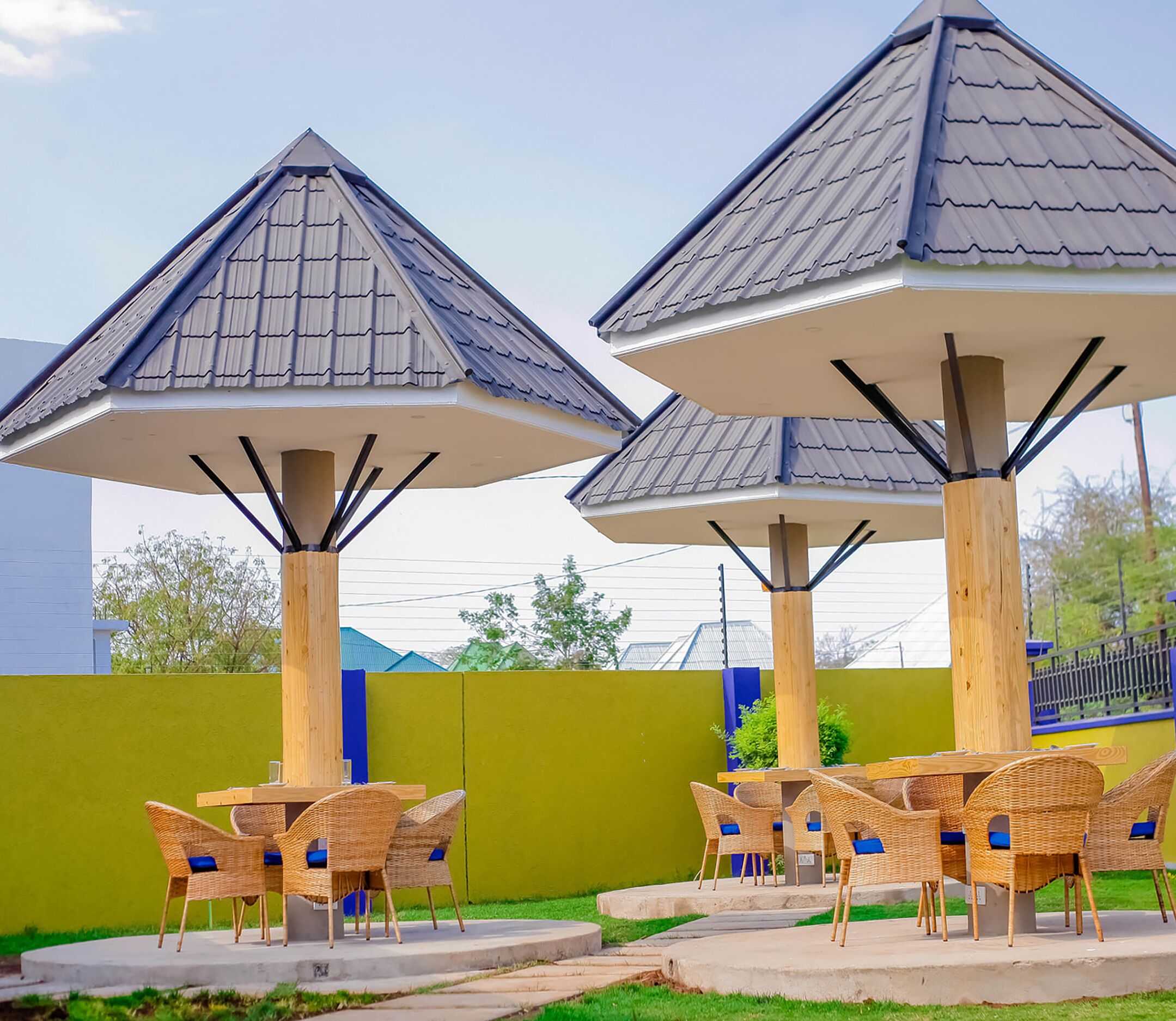 Buiten zitgedeeltes met parasols en rieten stoelen.
