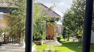 A residential property with a paved pathway leading to a covered outdoor seating area.