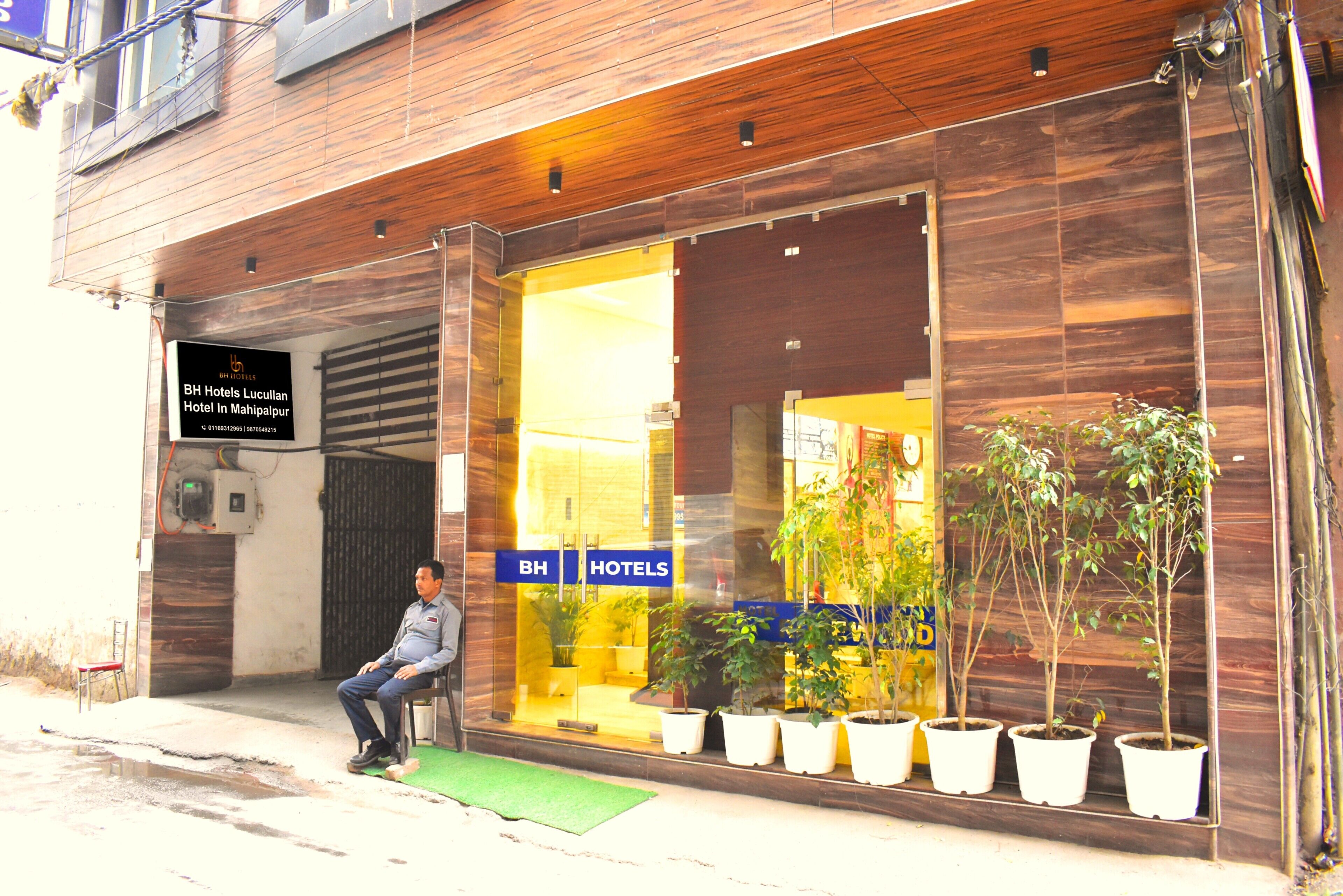 Entrada de un hotel con un letrero que dice 'BH Hotels Lucullan Hotel In Mahipalpur'.