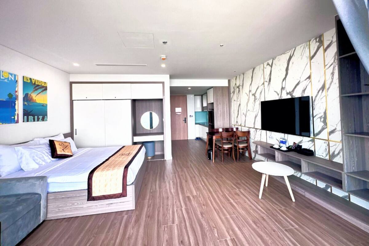 Une chambre d’hôtel moderne équipée d’un lit, d’un bureau, d’une télévision et d’un coin repas.