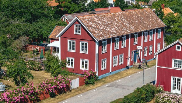 Un edificio rojo con múltiples ventanas y techo inclinado.