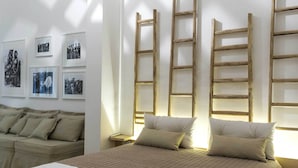 A neatly arranged bedroom with a bed, pillows, a nightstand, and a wooden ladder against the wall. - Trapetum-Salento Domus by Oikia Vacanze (Cursi)