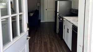Une petite cuisine équipée d’un réfrigérateur, d’une cuisinière et de placards.