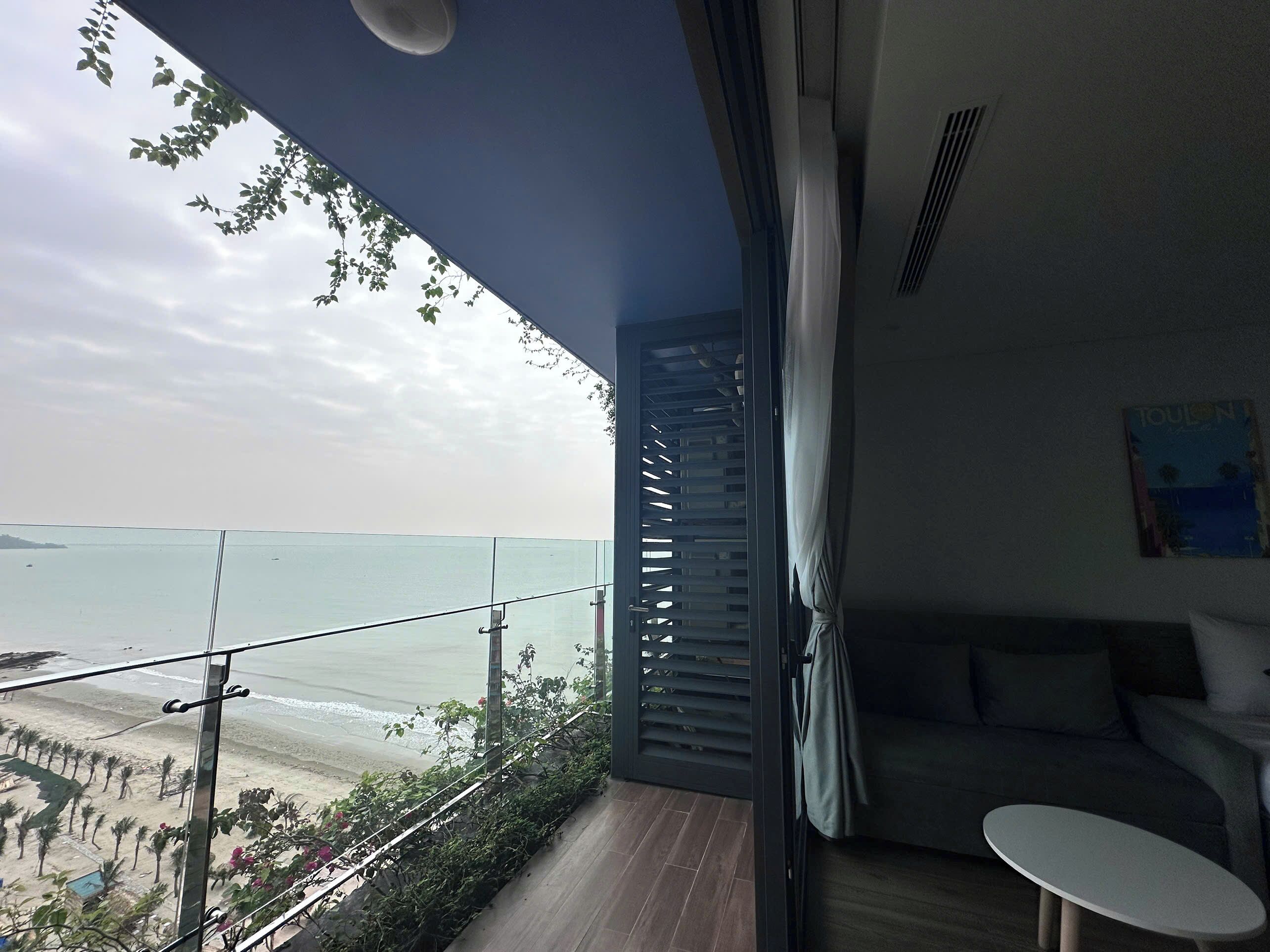 Un balcon avec vue sur la mer, un canapé et une petite table.