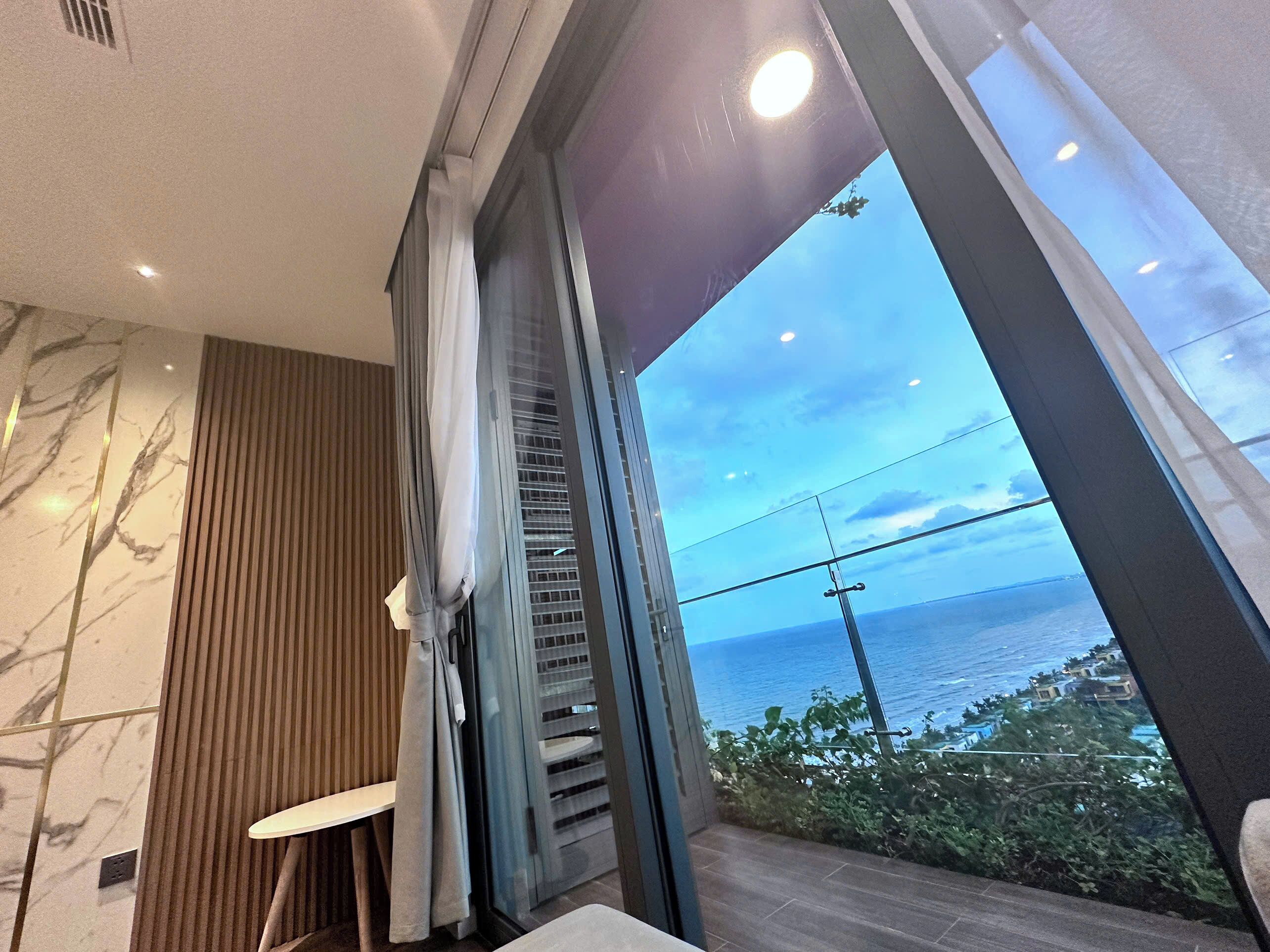 Ein modernes Badezimmer mit einem großen Fenster und Meerblick.