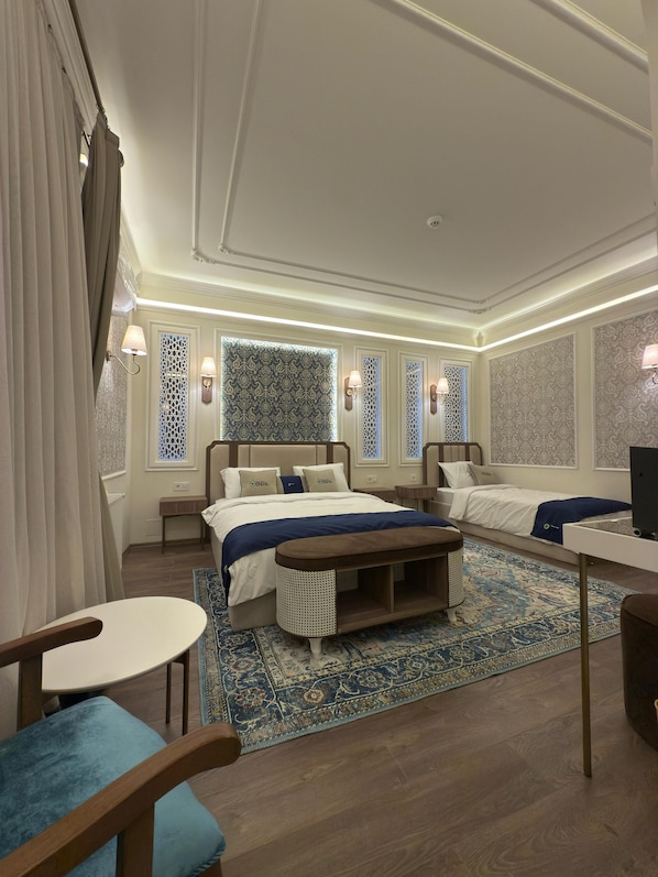 A modern hotel room with a large bed, a desk, and a chair. - Oasis Inn Budapest (Budapest)