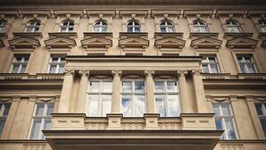 A building with a symmetrical facade, large windows, and a central entrance with a dark door. - Oasis Inn Budapest (Budapest)