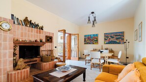 Ein Wohnzimmer mit Kamin, Essbereich und einer Couch.