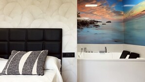 Une chambre à coucher avec une tête de lit noire et un mur blanc à texture, et une salle de bain avec une fresque représentant un coucher de soleil et une baignoire blanche.