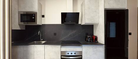 Una cocina moderna con microondas, horno y lavaplatos integrados.