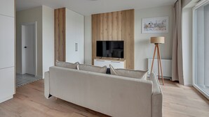 A modern living room with a sofa, TV, and lamp. - Horizon 169 - SeaView by GrandApartments (Gdansk)