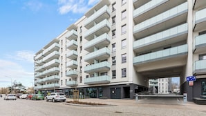 A multi-story residential building with balconies, a parking area, and a pedestrian pathway. - Horizon 169 - SeaView by GrandApartments (Gdansk)