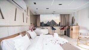 Ein modernes Hotelzimmer mit einem großen Bett, einem Schreibtisch und Blick auf einen Berg.