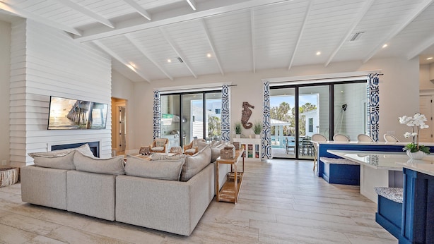 A spacious living area with a large sofa, a dining table, and a kitchen area with a blue countertop. - Luxury Resort-Like Home at St. Armands Circle and Lido Key Beach (Sarasota)