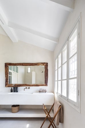 A bathroom with a large mirror, two sinks, a towel rack, and a window. - Historic Beauty Blends with Modern Design (Tel Aviv-Yafo)