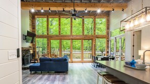 A spacious kitchen with a large island, wooden beams, and a view of the outdoors.