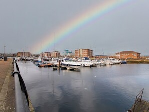 Boats docked along the marina's edge, adjacent to a scenic waterfront promenade.