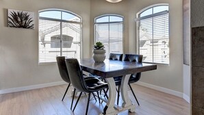 A dining area with a wooden table, black chairs, and a potted plant. - Scottsdale 3 Bdrm Condo w/Garage!  Great complex w/ Pool! (Scottsdale)