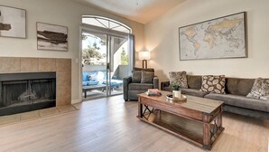 A living room with a fireplace, a sofa, a coffee table, and a world map on the wall. - Scottsdale 3 Bdrm Condo w/Garage!  Great complex w/ Pool! (Scottsdale)