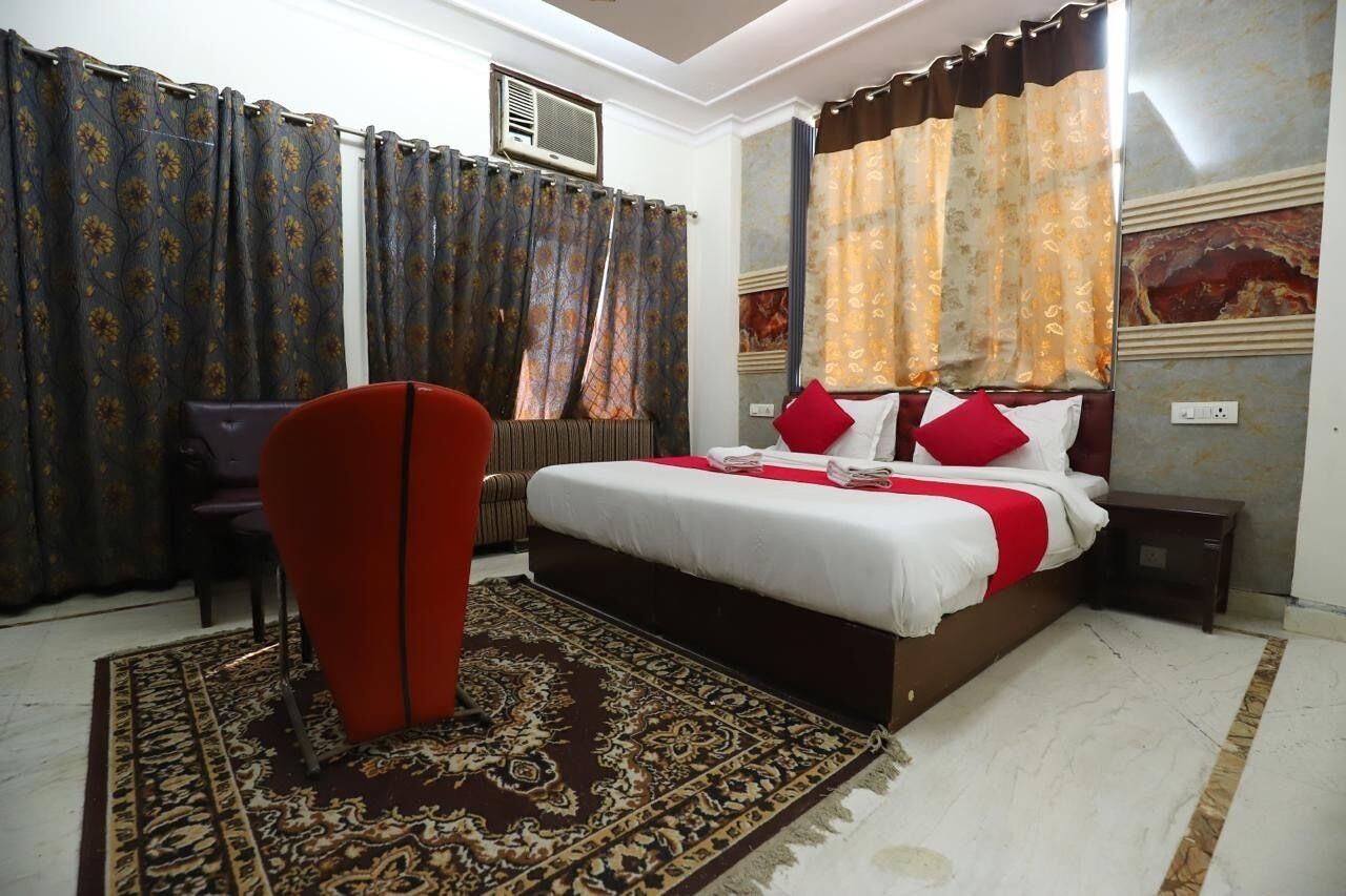 A bedroom with a bed, curtains, a chair, and a rug.