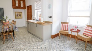 A kitchen with a central island, wooden cabinets, a dining area with chairs, and a patterned floor. - 4 South Park (Lincoln)