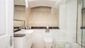 Ein modernes Badezimmer mit Waschbecken, Spiegel und Toilette in Weiß.