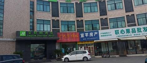 A multi-story building with commercial establishments on the ground floor, including a hotel and various shops.