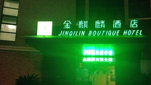 Fasaden på Jingilin Boutique Hotel med en neonreklamskylt och en tydligt markerad entré.