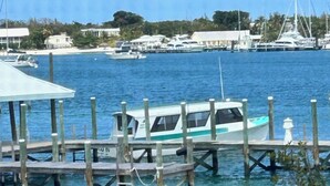 A boat docked at a pier with a clear view of the marina in the background. - Sea Bird 3/3 Overlooking the Sea of Abaco with Private Beach & dock access (green turtle cay)
