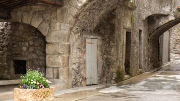 A stone corridor with arched ceilings and a planter with flowers.