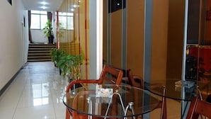 A hotel lobby with a glass table, chairs, a staircase, and potted plants. - Aishang Hotel (Shanghai Guoquan Road) (Shanghai)