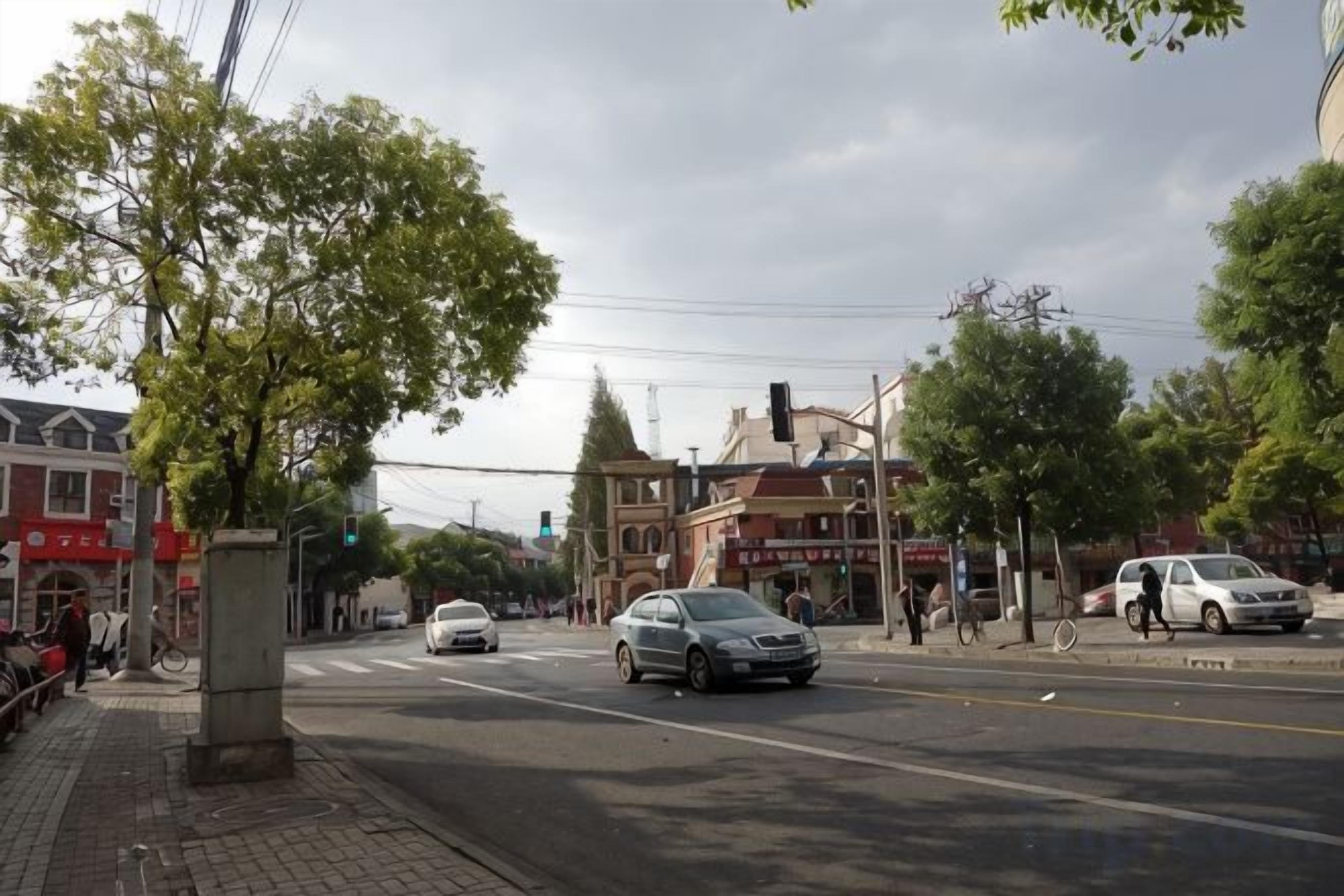 A street intersection with buildings, a traffic light, and a pedestrian crossing.