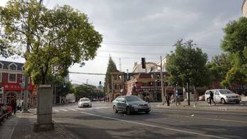 A street intersection with buildings, a traffic light, and a pedestrian crossing.