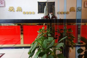 A reception area with a glass partition, a red wall, and a potted plant. - Aishang Hotel (Shanghai Guoquan Road) (Shanghai)