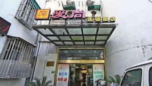 A hotel entrance with a glass canopy, potted plants, and a sign indicating a special rate. - Aishang Hotel (Shanghai Guoquan Road) (Shanghai)