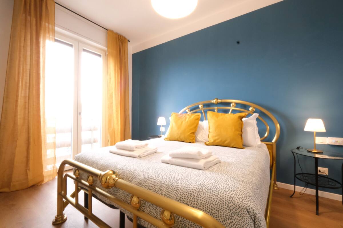 Ein Schlafzimmer mit einem Bett, Vorhängen und einem Nachttisch.