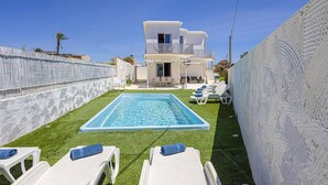 A modern villa with a swimming pool, outdoor seating, and a decorative wall. - Villa Marena by Villa Plus (Santa Maria del Focallo)