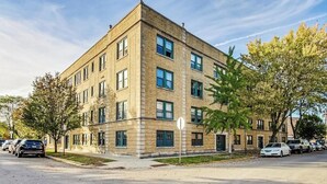 Un immeuble à plusieurs étages, doté d’une façade symétrique, de grandes fenêtres et d’un toit plat.