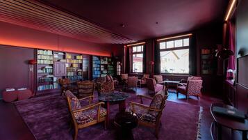 Una biblioteca con estanterías, asientos cómodos y ventanas amplias.