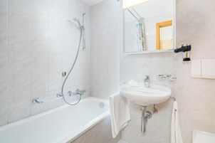 Un baño moderno con bañera, lavabo y ducha.