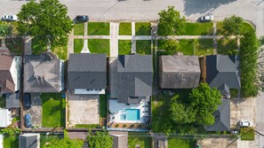 Vista aérea de uma área residencial com casas, piscina e rua.