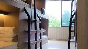 A bunk bed room with a window, a ladder, and a built-in shelf.