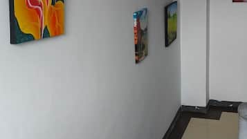 Escada com corrimão e parede decorada com três obras de arte emolduradas.