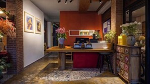 Une cuisine moderne avec un mur d’accent rouge, une table en bois et divers appareils de cuisine.