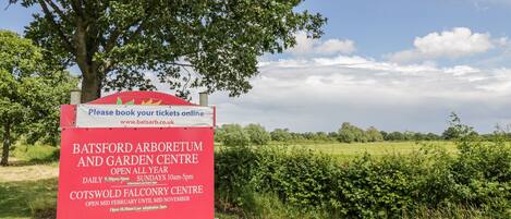 A sign for Batsford Arboretum and Garden Centre, open daily from 9:30 am to 5 pm, and Cotswold Falconry Centre, open from mid-February to mid-November.