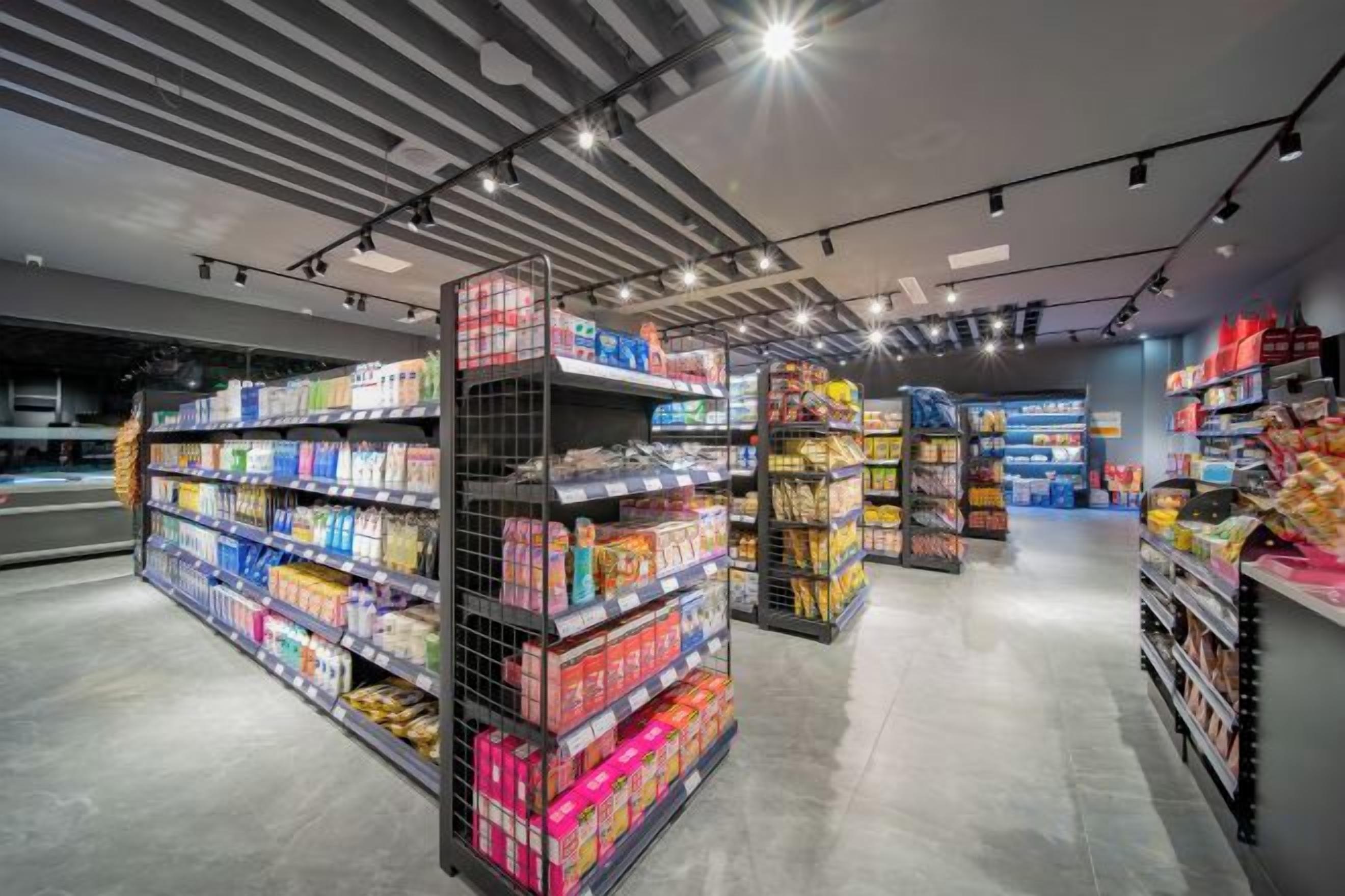 A modern supermarket interior with well-organized aisles and shelves stocked with various products.