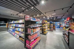 A modern supermarket interior with well-organized aisles and shelves stocked with various products. - Kunlun Hotel (Nantong)