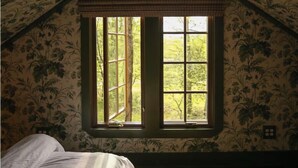 Un dormitorio con una ventana grande, una cama y una alfombra.