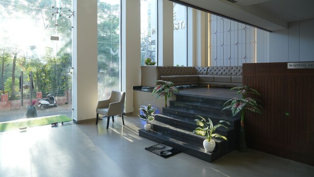 A modern waiting area with a sofa, chairs, and potted plants.